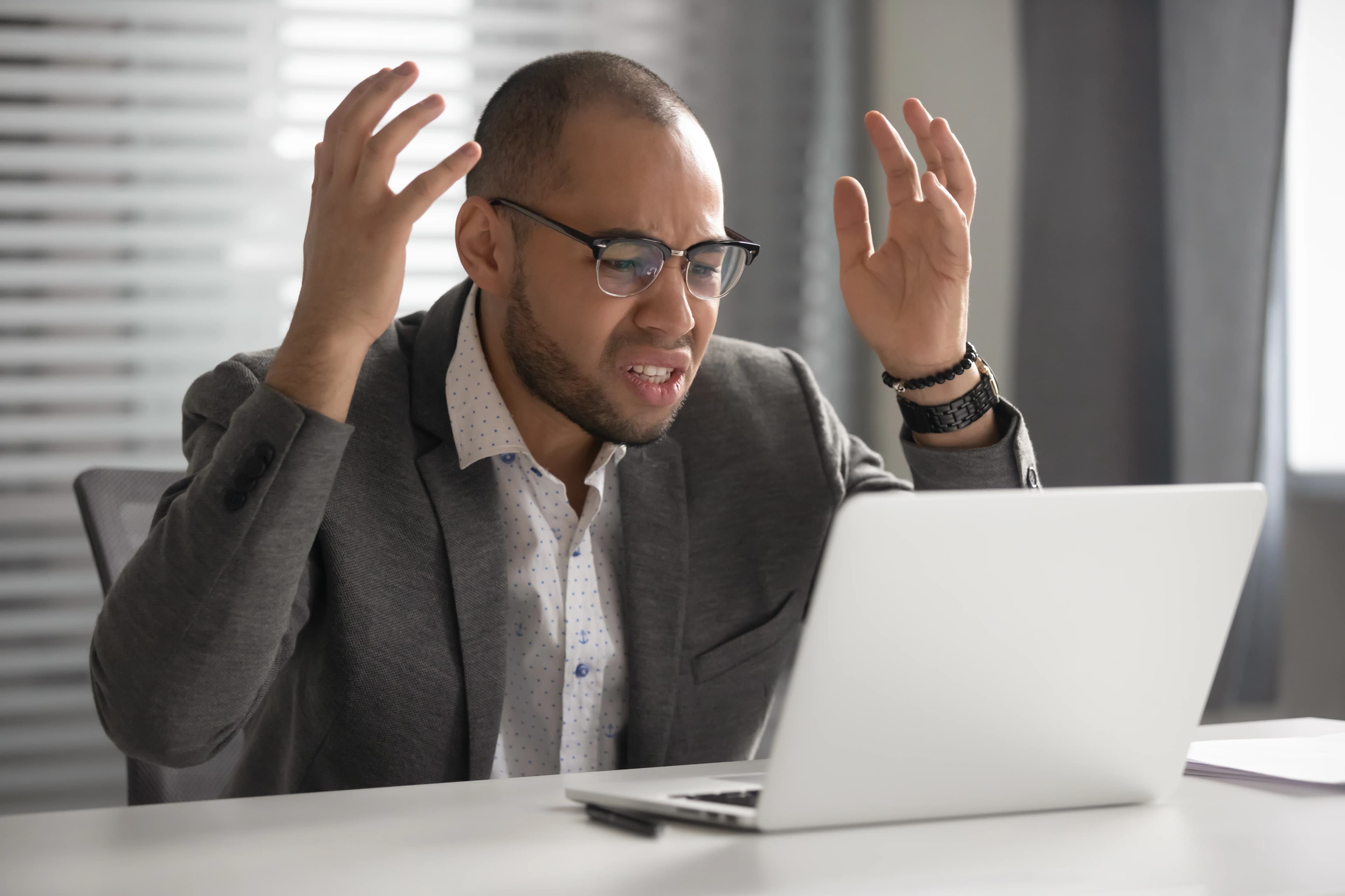 A frustrated professional reacts to unpredictable results on his laptop screen